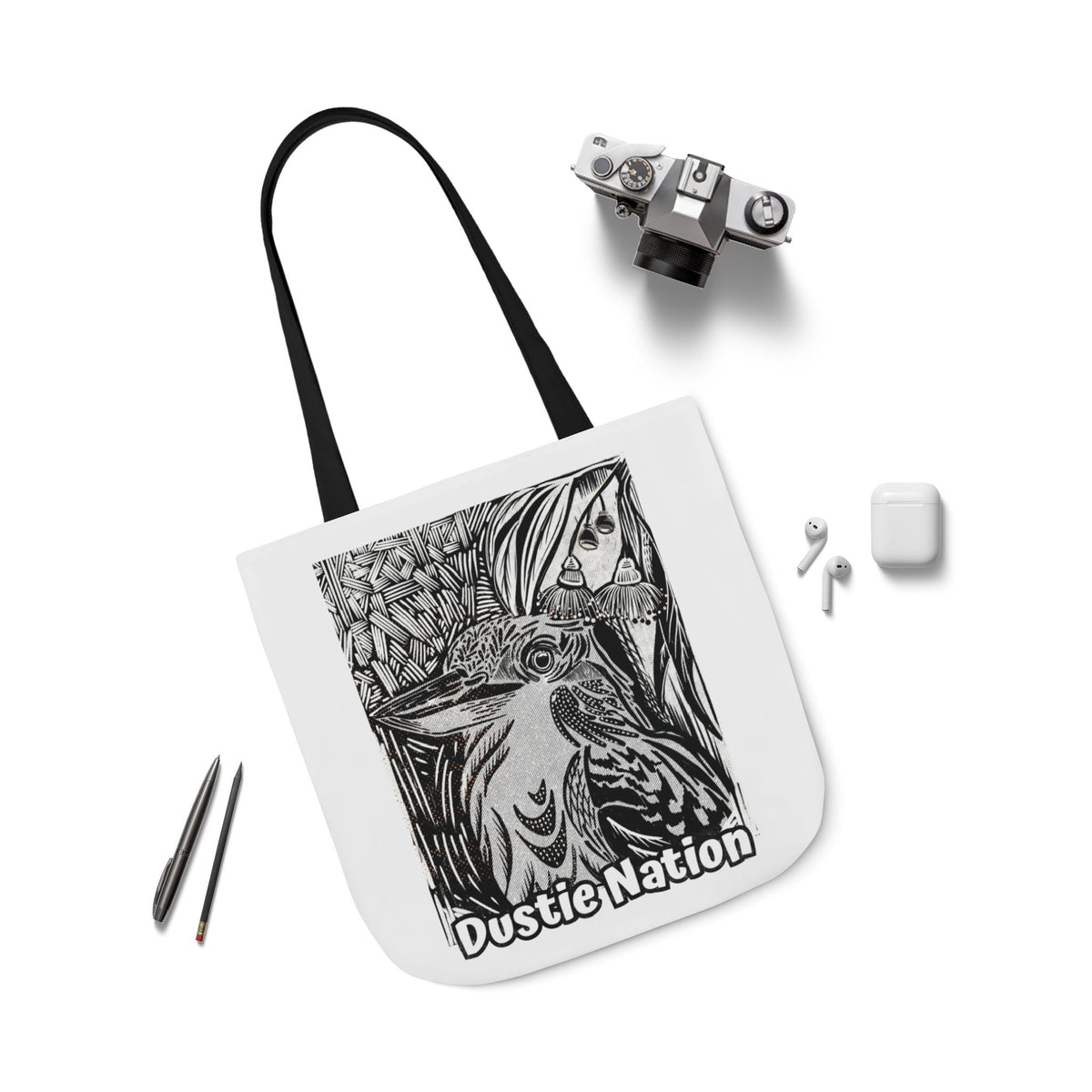 Durable tote bag with custom artwork of a Kookaburra on a white tote bag with black handle.  Camera and ipad with the bag