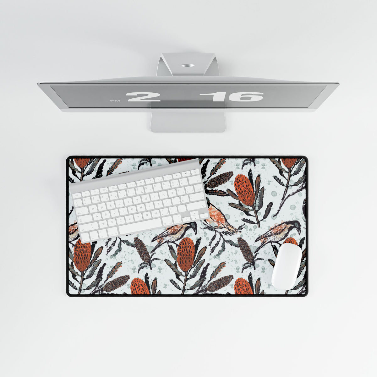Desk setup with a computer, keyboard, mouse, and decorative mouse pad. Mouse pad shows hand drawn artwork of Australian honey eating birds
